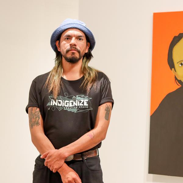 Atticus Mercredi stands near the portrait he painted of his mother.