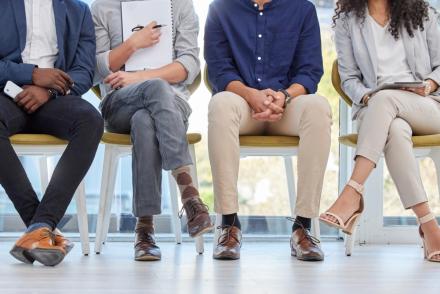 closeup of students' legs dressed in business attire sitting on chairs